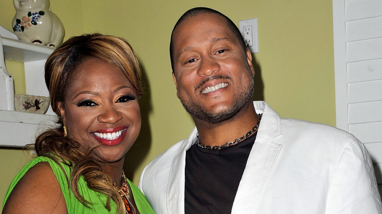 Pat and Gina Neely smiling at the camera, in a kitchen
