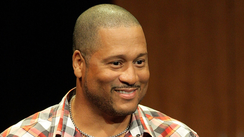Pat Neely smiling on stage in a plaid shirt