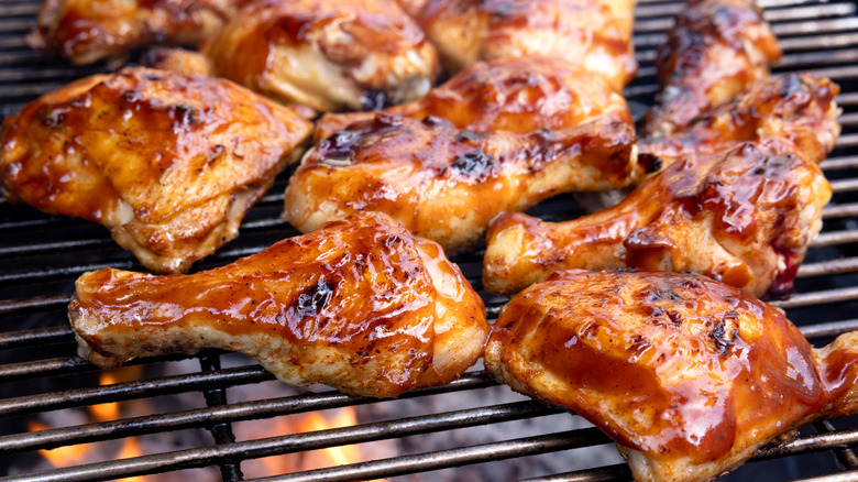 Chicken with barbecue sauce cooking on a grill