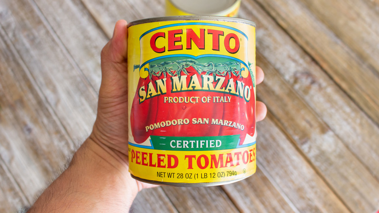 hands holds large can of Cento peeled tomatoes