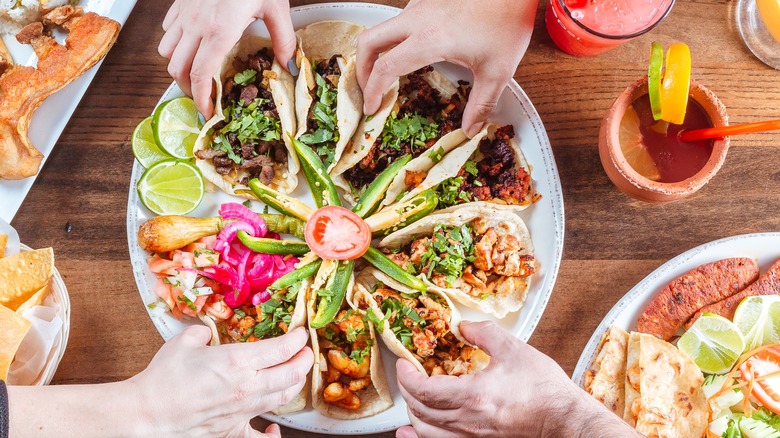 People sharing taco platter in Mexican restaurant