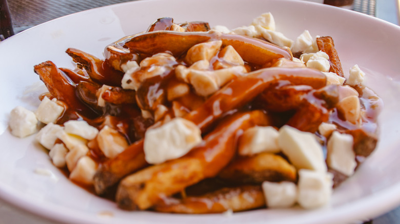 Sweet potato fry poutine in a white plate.