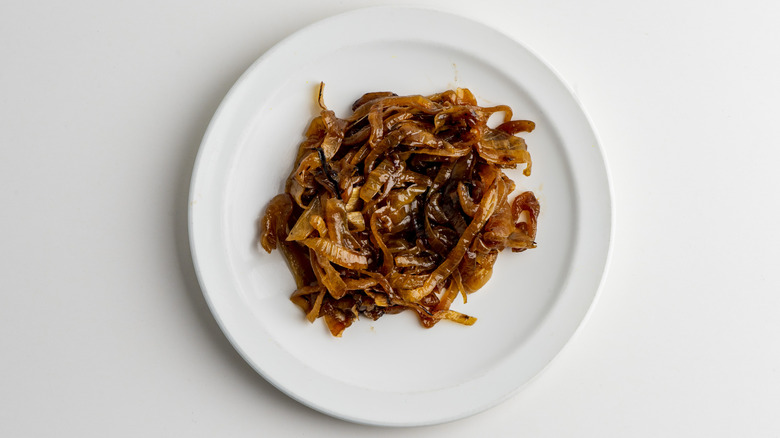 Caramelized onions on a white plate on white background