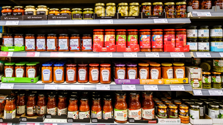 Grocery store shelf with various jars of pasta sauce