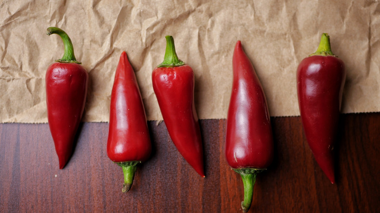 Red jalapeños lined up on parchment paper