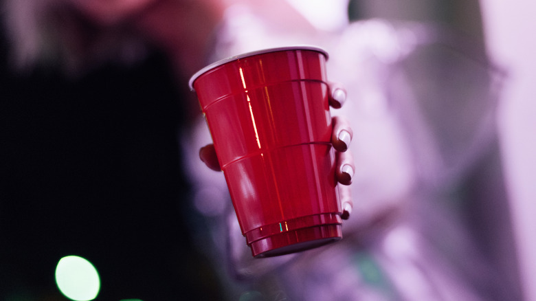 A person holding a red solo cup with a blurry background