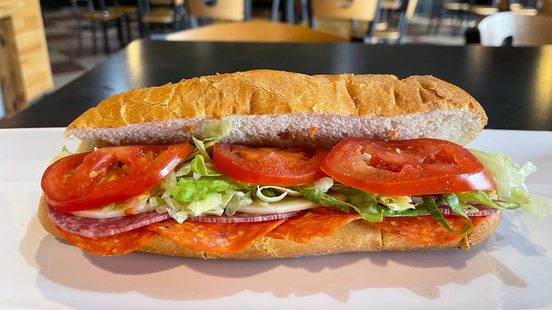 Italian hoagie with meat, cheese, and vegetables on a restaurant countertop