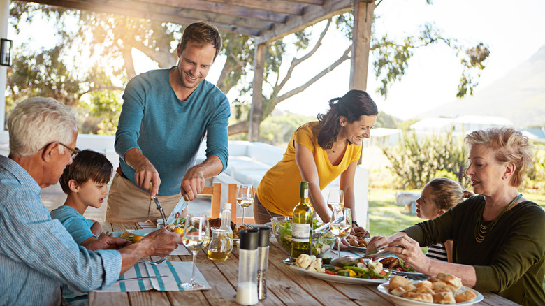 Family eating dinner at the table together outside
