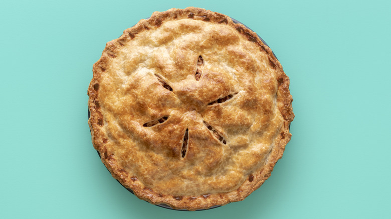 Pie with browned crust on turquoise background