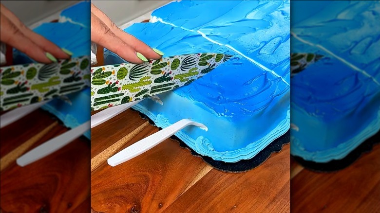 Cake with forks stuck into the sides and a knife cutting down into the cake