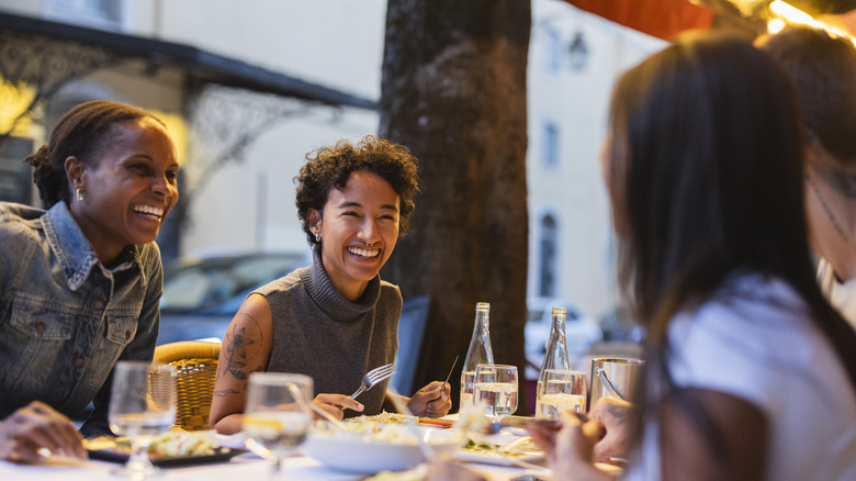 A group of friends eating together, having a great time.