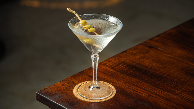 A dirty martini on a wooden surface