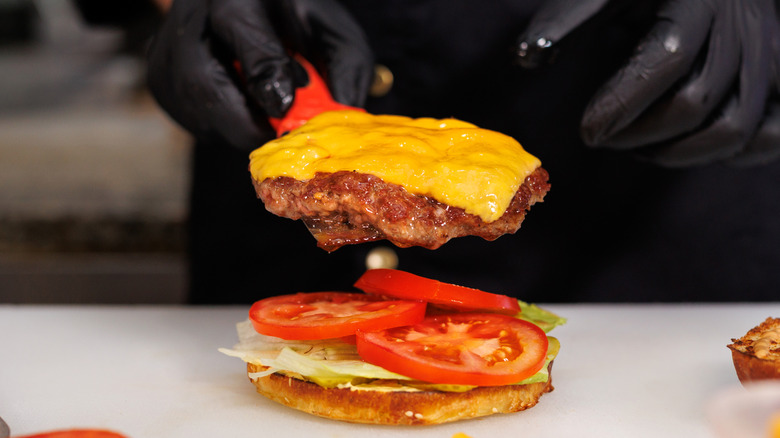 Cook building fast food cheeseburger