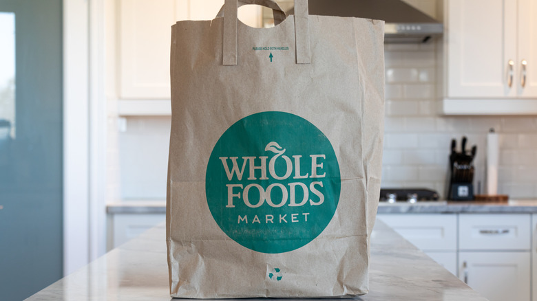 A Whole Foods Market grocery bag on top of a kitchen counter