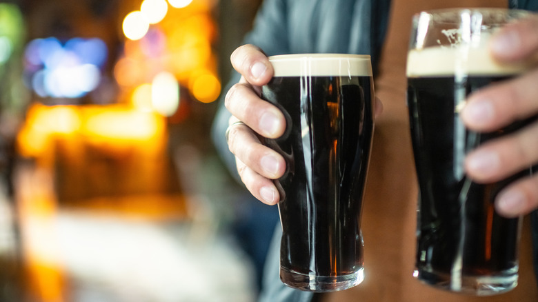 Hands holding stout beers