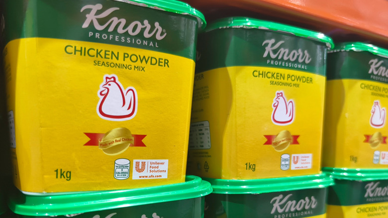 Large tubs of chicken powder stacked on a grocery store shelf
