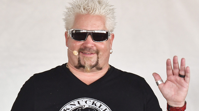 Guy Fieri waves to fans during a cooking demo