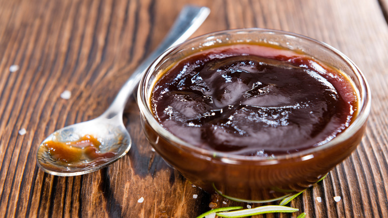 A small bowl of barbecue sauce with a spoon