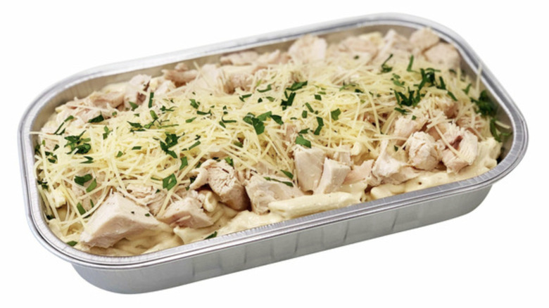 Costco chicken Alfredo in foil baking tray with parmesan on top.