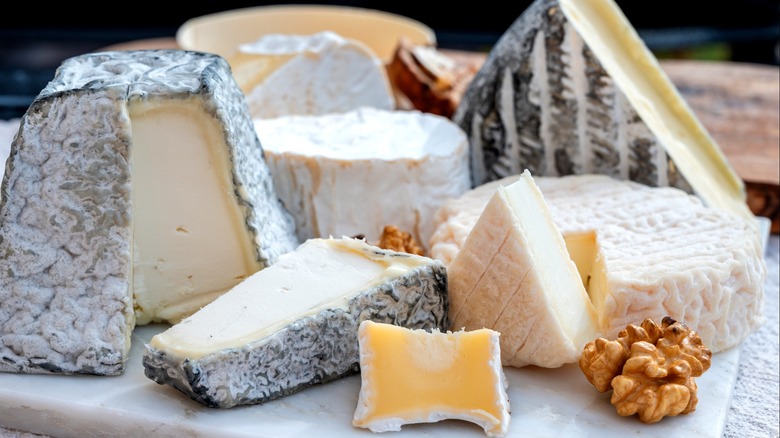An assortment of French cheeses on a marble platter