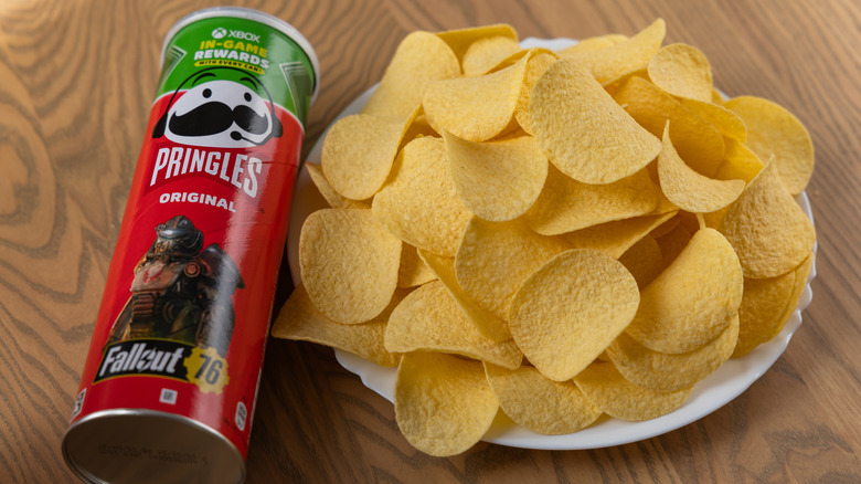 Pringles chips sitting on a plate beside a Pringles can.