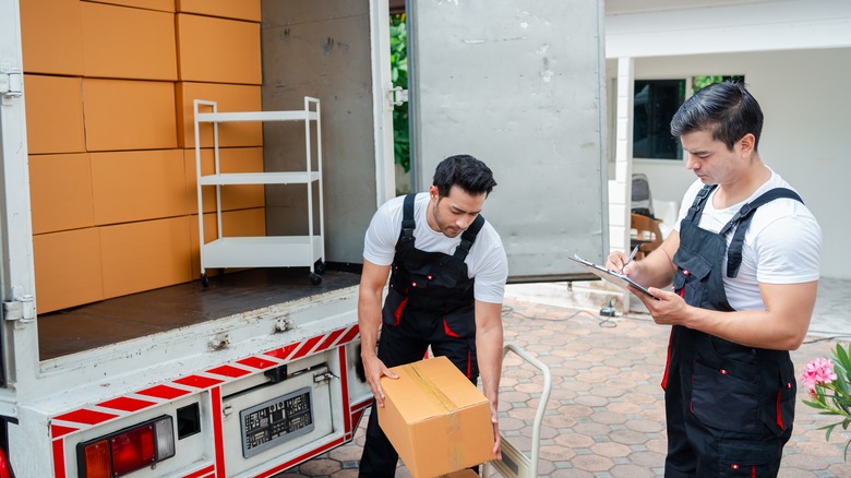 Two men unload boxes from delivery truck
