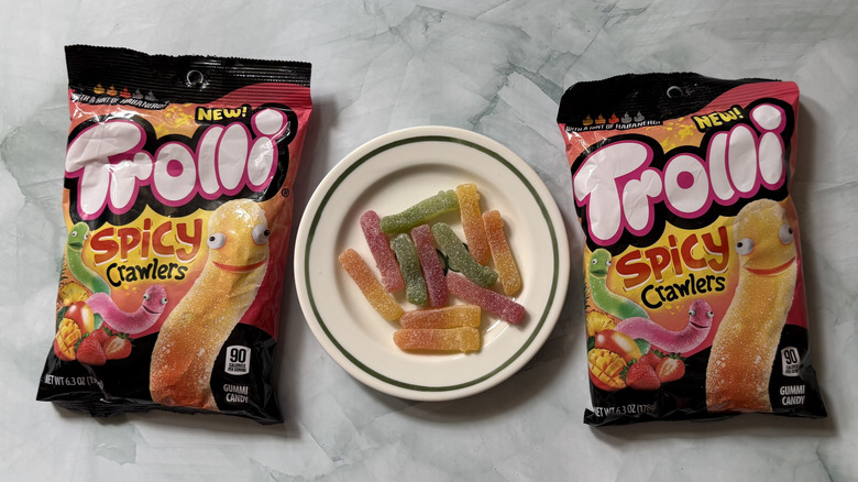 Two bags of Trolli Spicy Crawlers and a plate of them