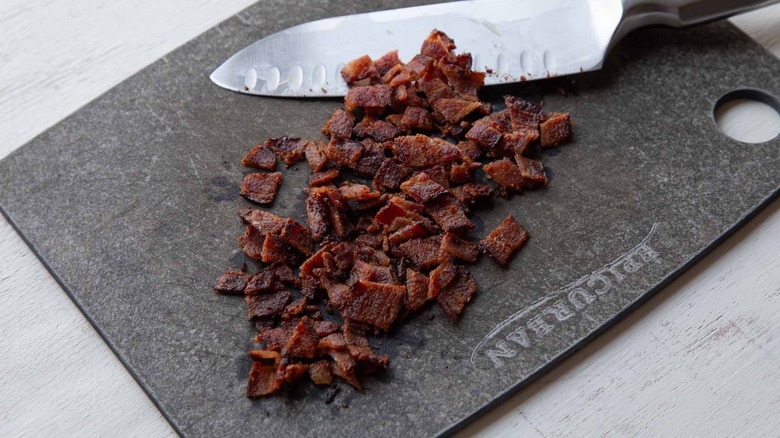 Chopped bacon on cutting board with knife