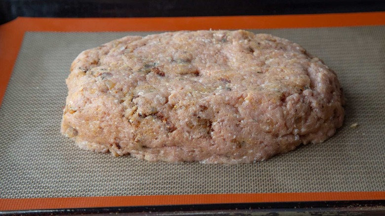 Raw meatloaf on baking sheet