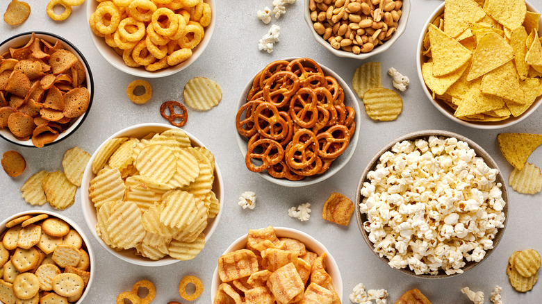 Variety of crunchy snack foods in bowls on table