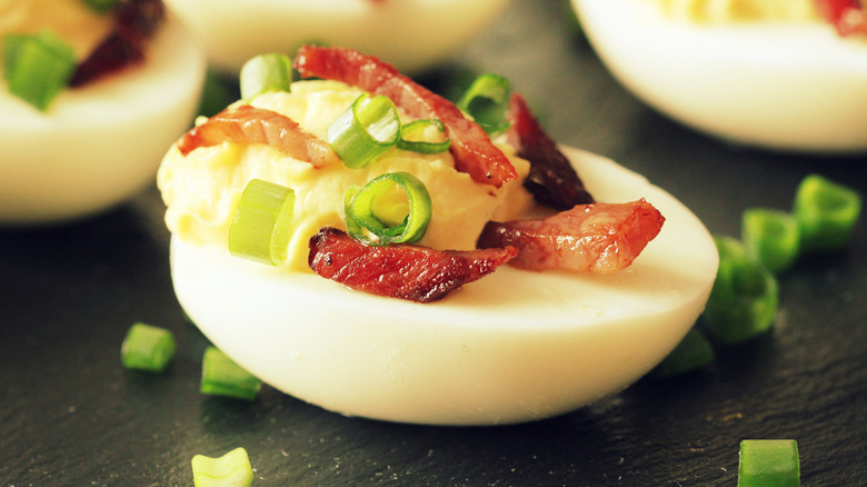 Close-up of deviled eggs with scallions and bacon