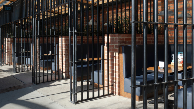 row of restaurant booths separated by prison bars