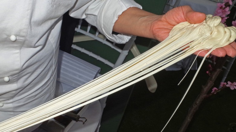 Threads of su filindeu being stretched out.