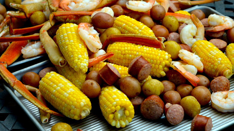 Seafood boil containing shrimp, corn on the cob, sausage, potatoes