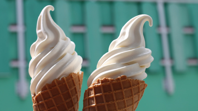 A closeup of two soft serve ice cream cones.