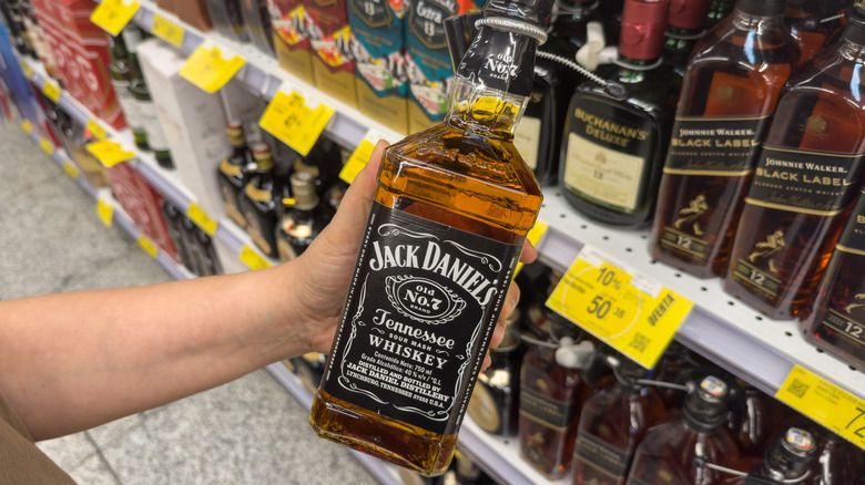 Someone holding a bottle of Jack Daniel's whiskey in a store