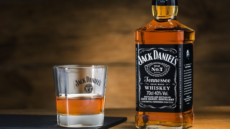 A bottle of Jack Daniel's whiskey next to a glass of whiskey
