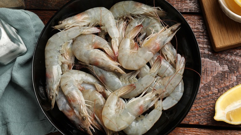 Fresh, raw shrimp in bowl, ready to be cooked.