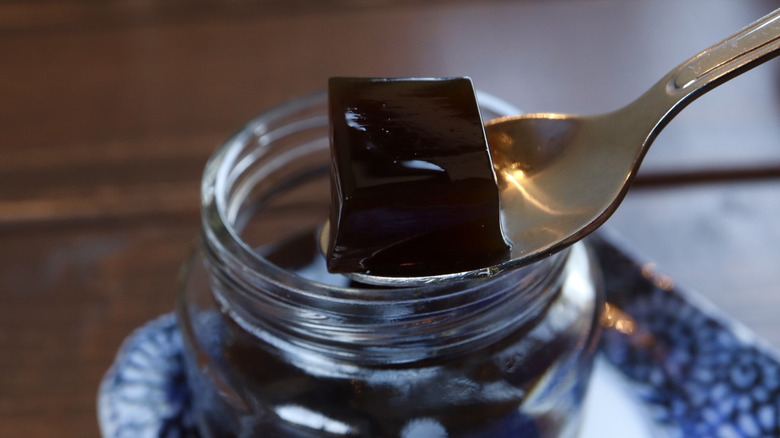 Spooning cubed coffee jelly from a glass jar