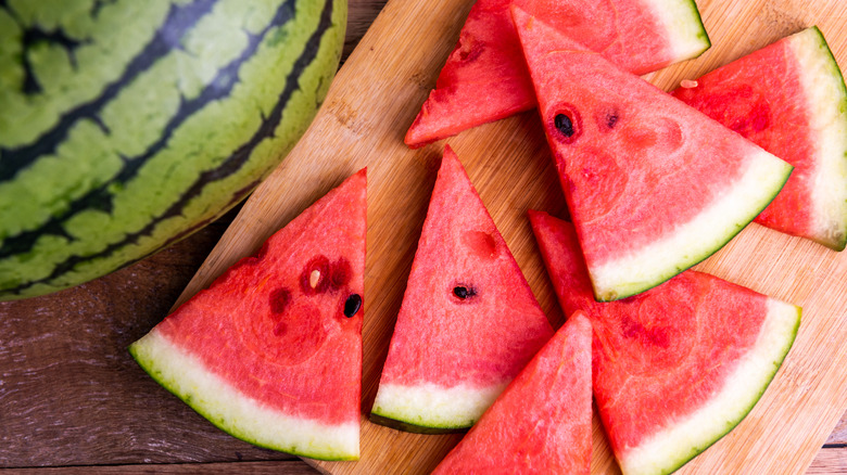 Slices of watermelon on a wooden cutting board.