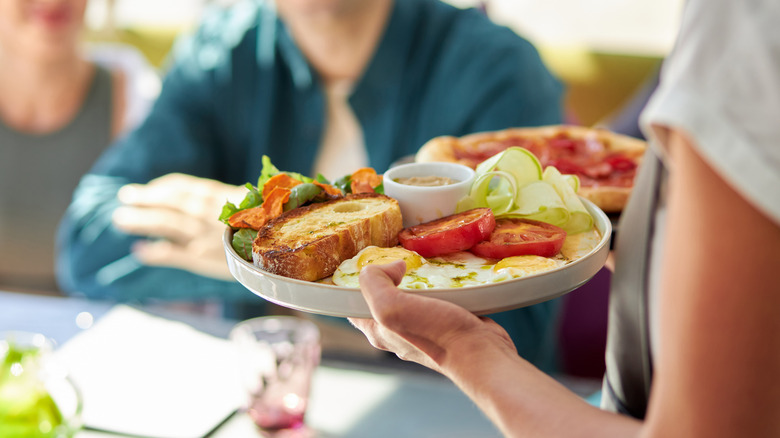 A server bringing food to a table.