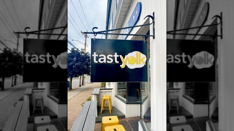 An exterior sign for The Tasty Yolk