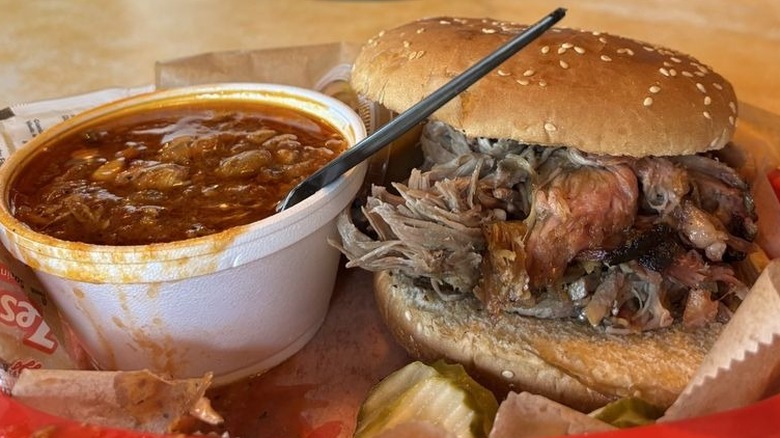 A styrofoam cup of Brunswick stew with barbecue sandwich