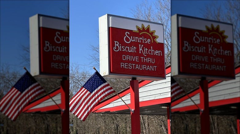 Red and white Sunrise Biscuit Kitchen exterior sign with an American flag on the left