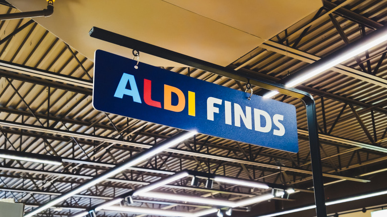 A blue ALDI Finds sign hanging inside a ALDI location