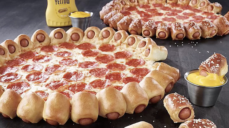 two pizza pies from pizza hut featuring a hot dog crust