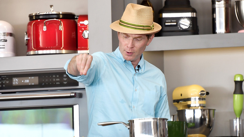 Chef Bobby Flay cooking in a kitchen with appliances in the background