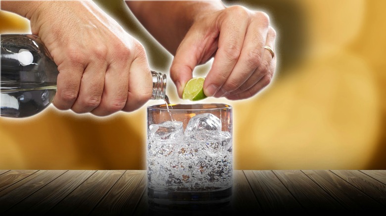 A bartender preparing a cocktail with lime