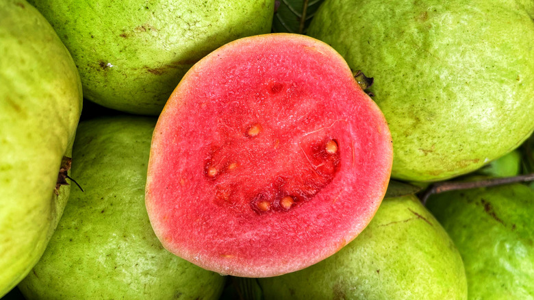 Sliced guava on top of whole guavas