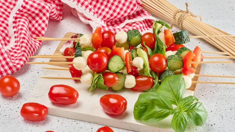 skewers with cucumber slices, chunks of cheese, deli meat, and cherry tomatoes